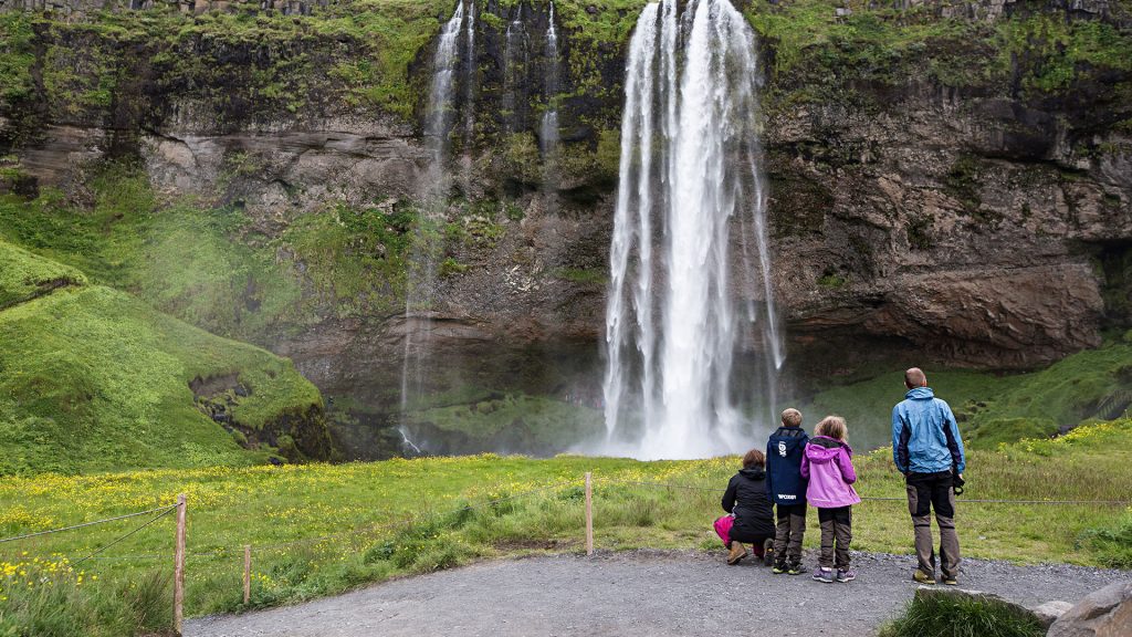 Tourists at the base of the waterfall